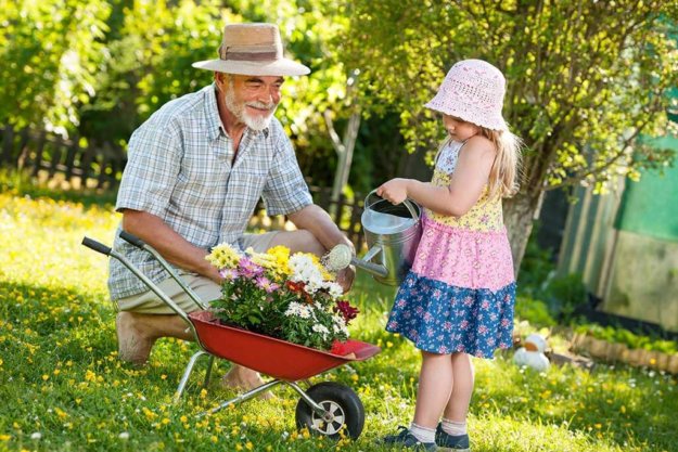 Happy grandfather with his granddaughter in the garden Happy grandfather with his granddaughter in the garden