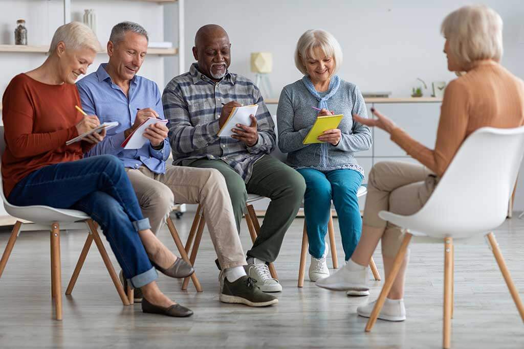 Multiracial group of elderly men and women having educational class