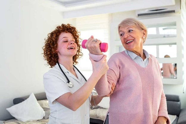 Senior woman after stroke at nursing home exercising with professional physiotherapist Senior woman after stroke at nursing home exercising with professional physiotherapist