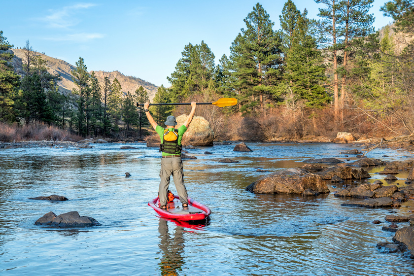stand up paddling on mountain river
