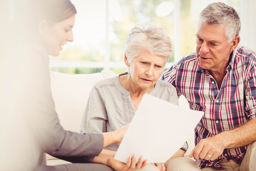 Smiling businesswoman showing documents to senior couple Smiling businesswoman showing documents to senior couple