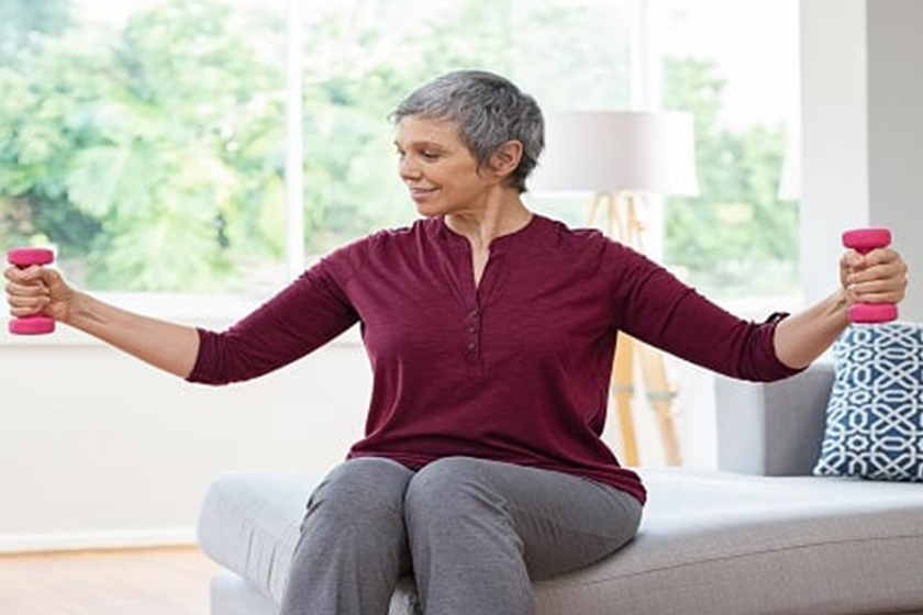 Senior woman lifting weights and working out at home Senior woman lifting weights and working out at home