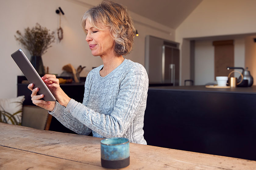 Mature Woman At Home Buying Products Or Services Online using digital tablet Mature Woman At Home Buying Products Or Services Online using digital tablet