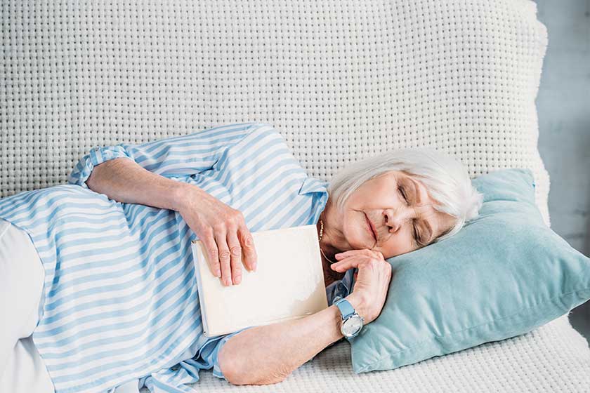Portrait of senior woman with book sleeping on sofa at home Portrait of senior woman with book sleeping on sofa at home