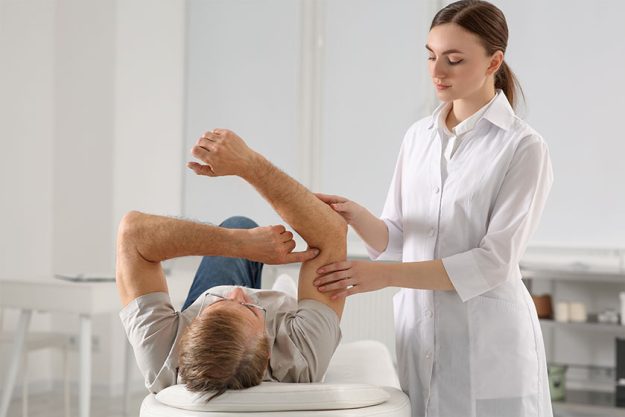 Professional orthopedist examining patient's arm