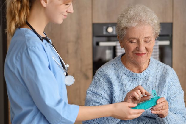 Senior woman with doctor taking pills
