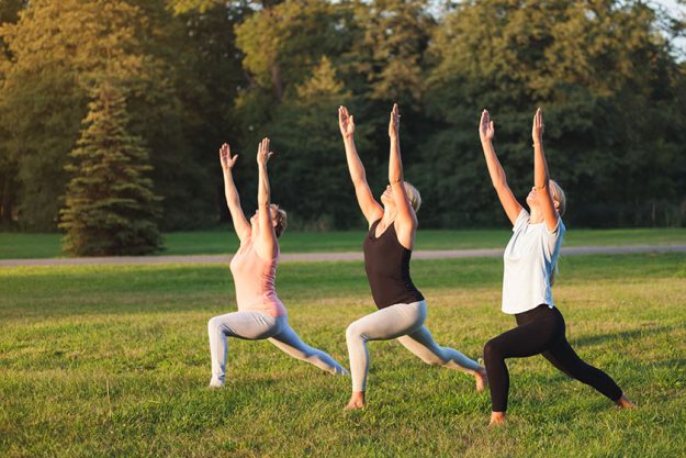 Yoga at park, group of mixed age women
