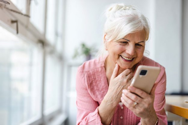 Smiling senior woman using smartphone