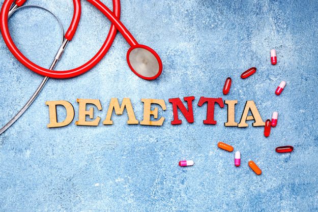 Word DEMENTIA with pills and stethoscope on color background Word DEMENTIA with pills and stethoscope on color background