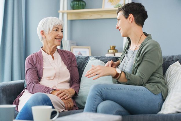 I love spending time with my mum. an attractive young woman sitting on the sofa and talking with her happy senior mother at home