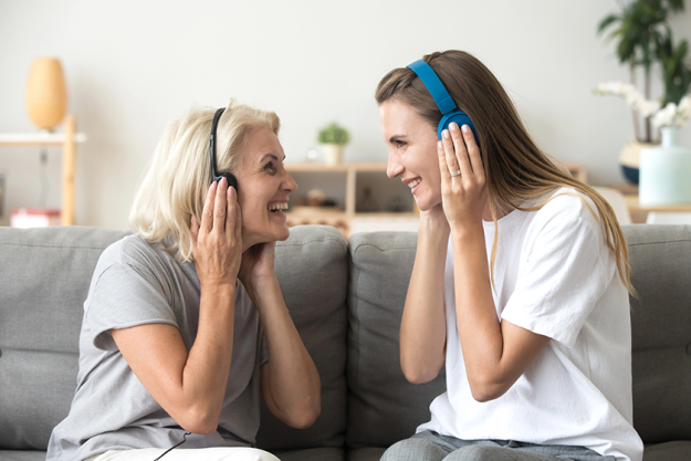 happy-senior-mother-and-adult-daughter-listening-music
