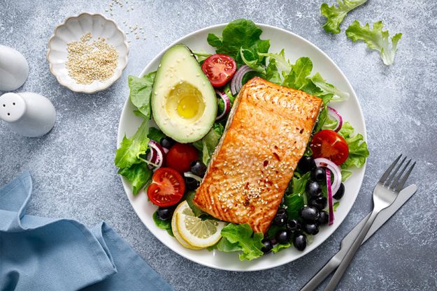 Grilled salmon fish fillet and fresh vegetable salad