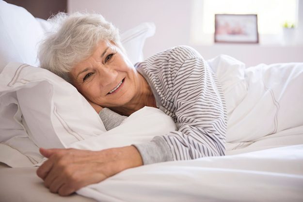 Mature woman smiling in bed