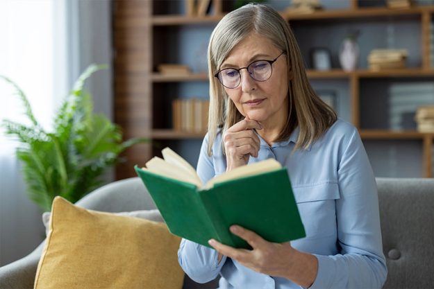 Senior woman with glasses sitting on a sofa,