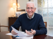 Portrait Of Happy Senior Man Reviewing Domestic Finances