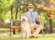 Senior blind on bench with dog